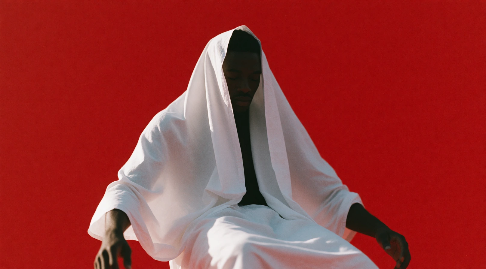 16:9 keyframe, high-grade cinematic still with raw avant-garde treatment, heavy film grain, soft diffusion, and bold imperfect black line accents, --sref 3391735275 4130068682 943157575 A Black man floats weightlessly in the center of the frame, drap