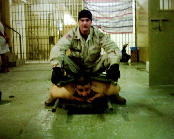 uS Soldier torturing an Iraqi man in Abu Ghraib, Iraq 2003