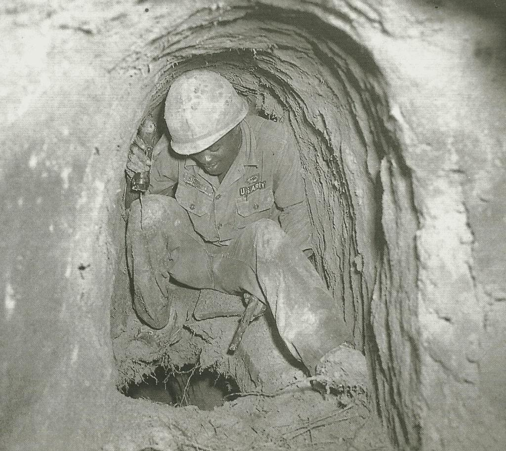 a US "tunnel rat" explores a hole between floors of a Viet Cong tunnel system, Vietnam, 1968