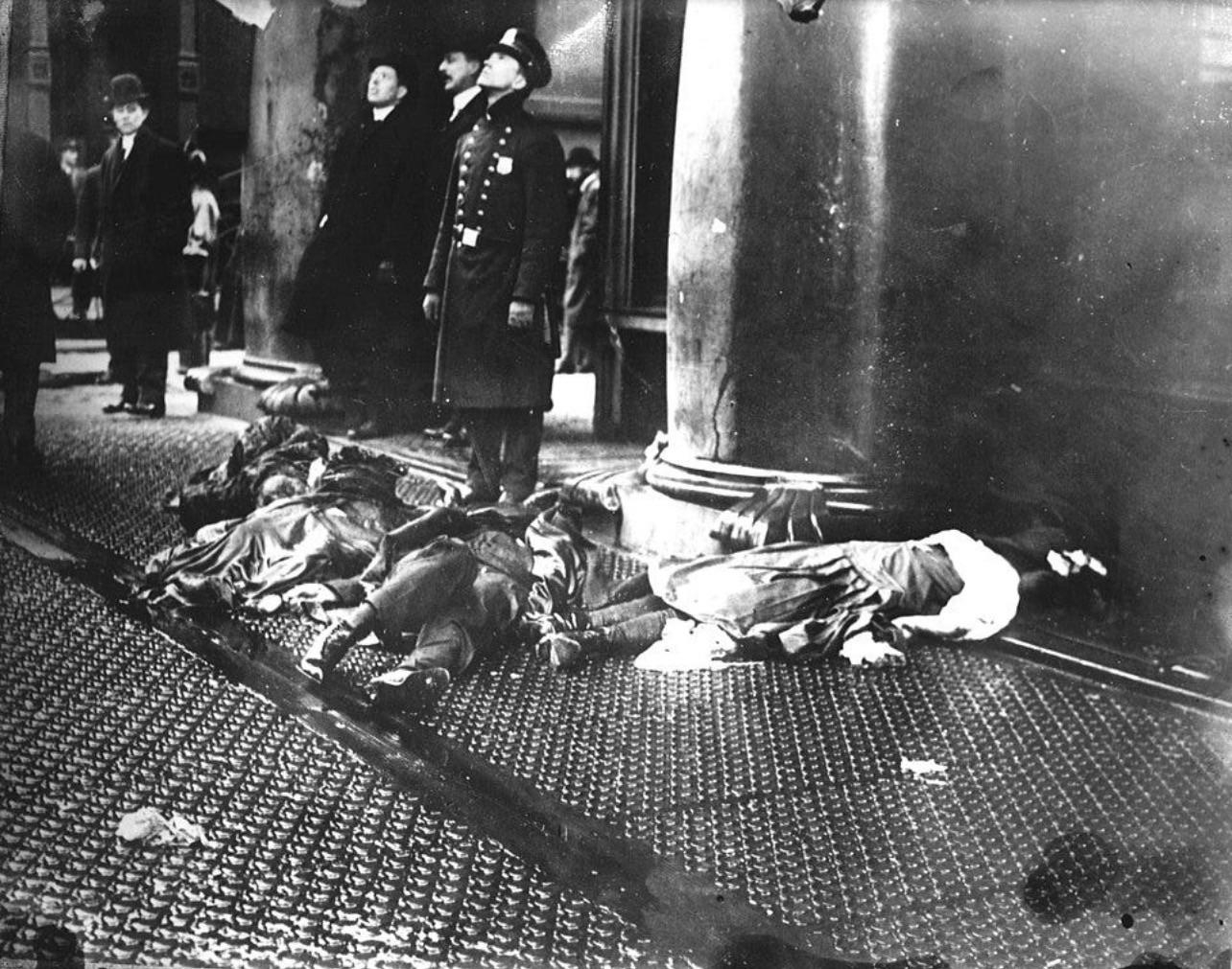 march 25th, 1911, bystanders look up at the burning Triangle Shirtwaist Factory next to the bodies o…