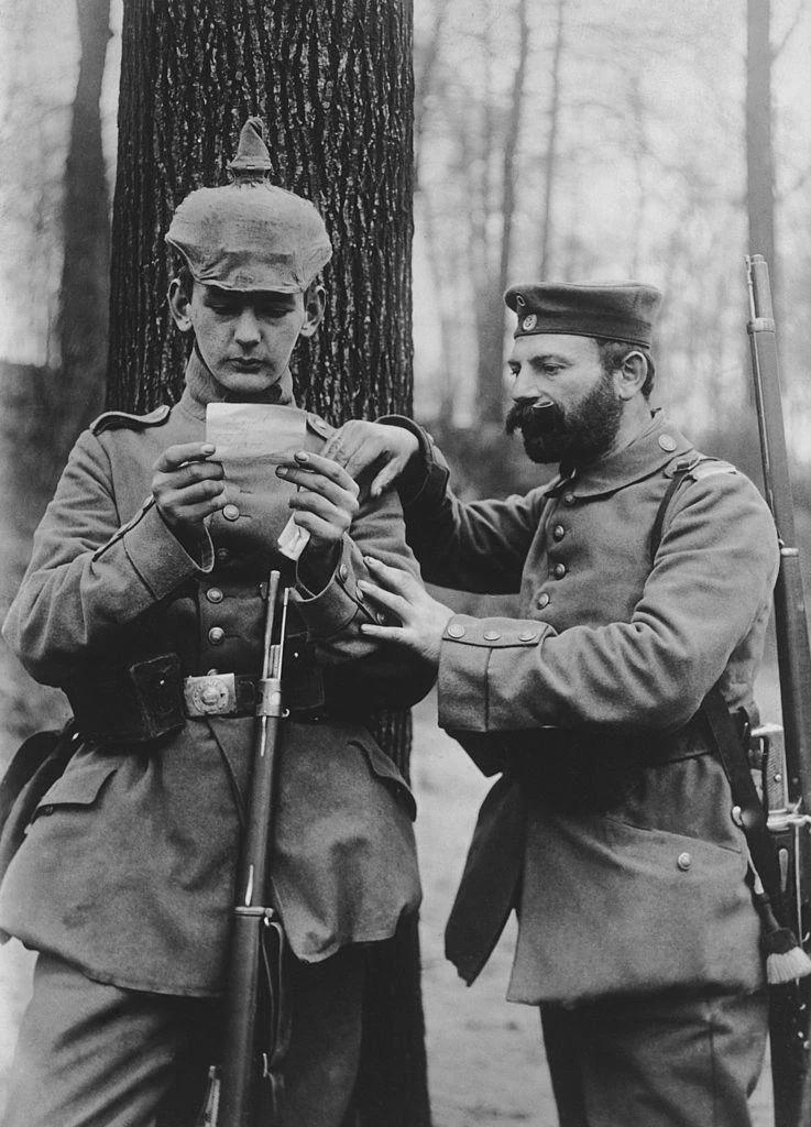 father and son from the same German regiment read a letter from their respective wife and mother at…