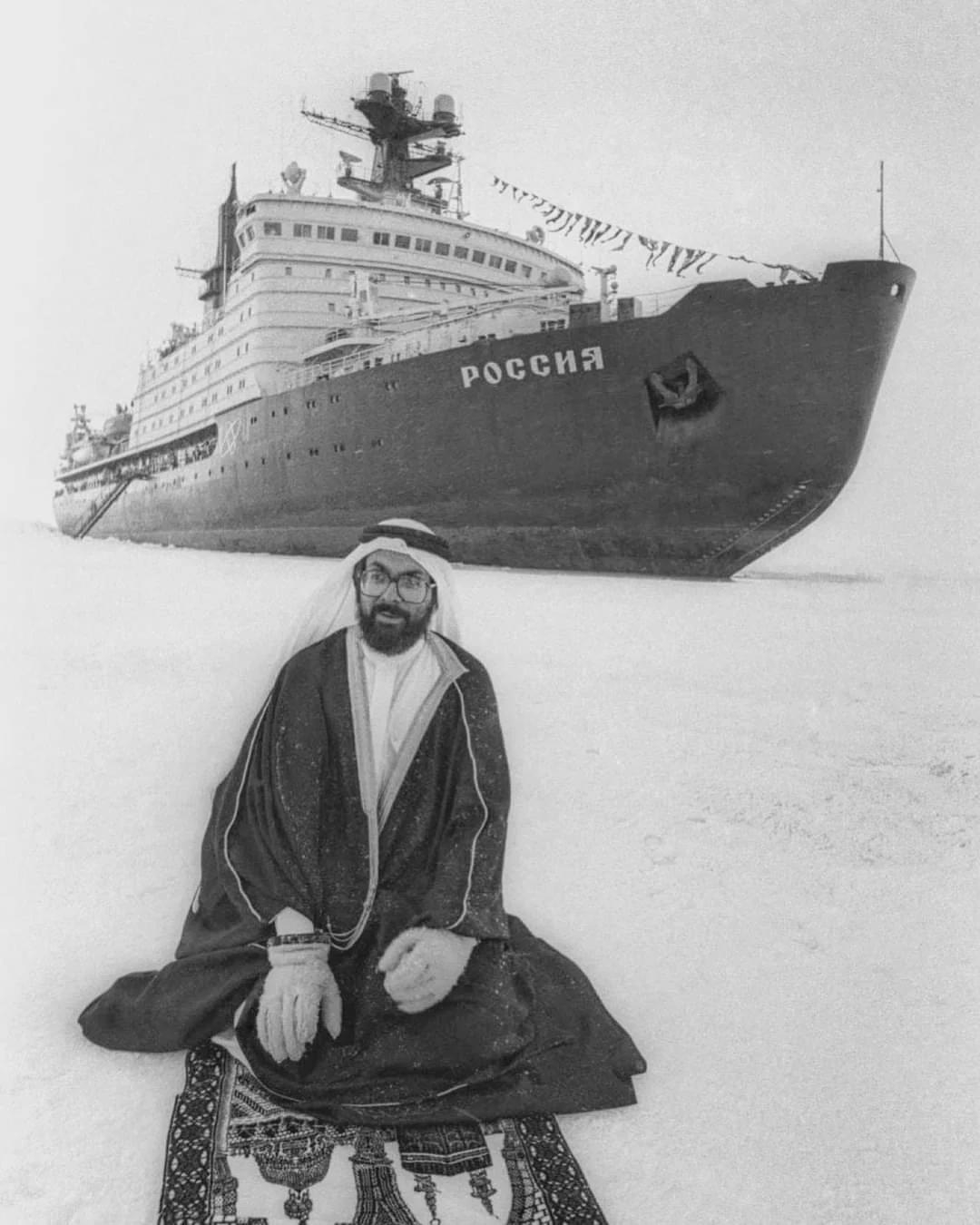 a tourist from Saudi Arabia prays at the North Pole against the background of a Soviet nuclear icebr…