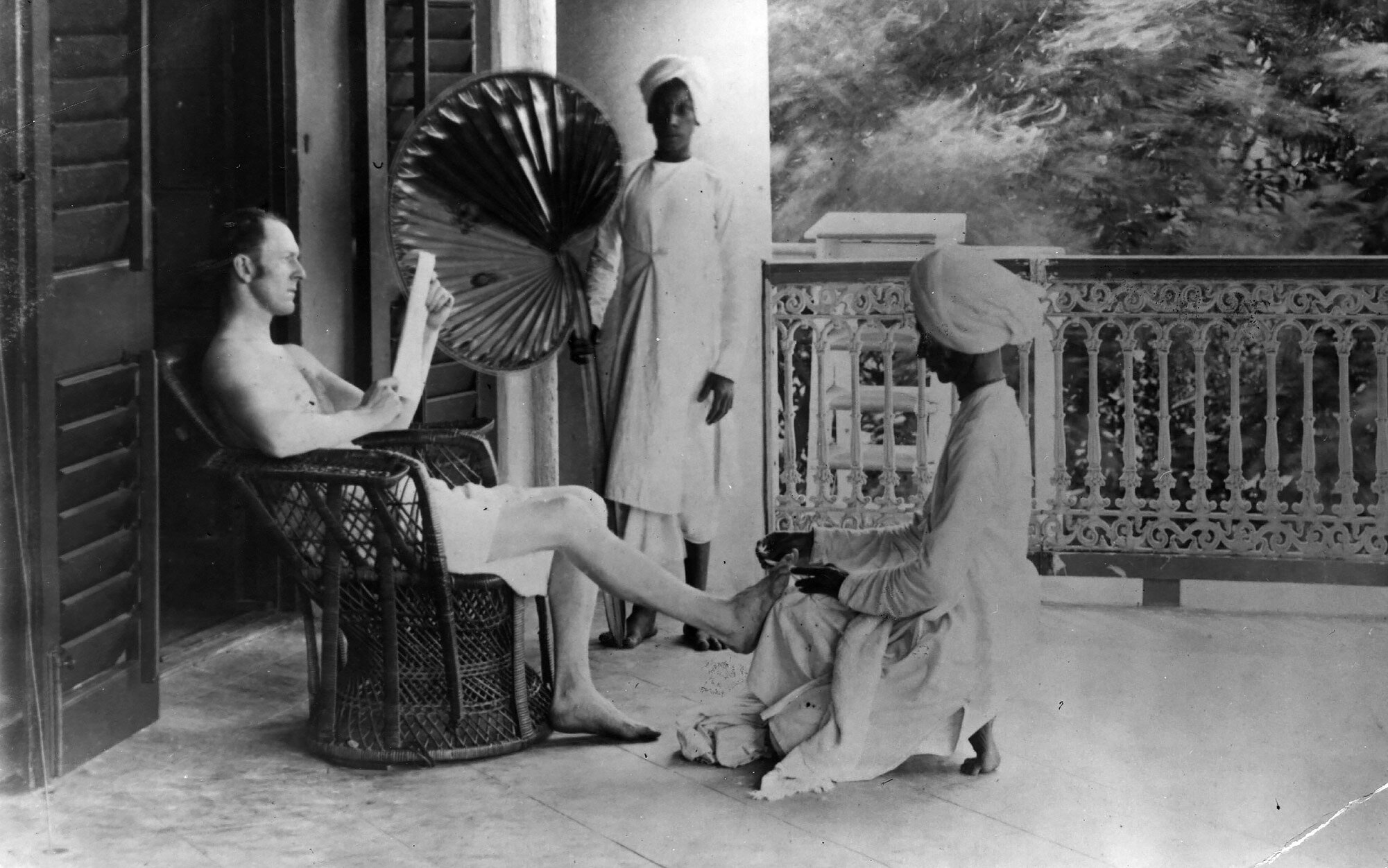 a British officer reading a newspaper while being fanned with a palm frond &amp; getting a pedicure…