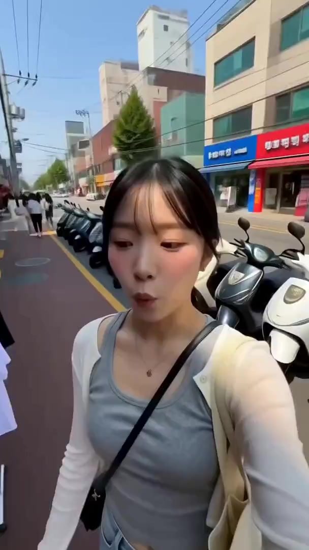 LOCATION: A lively Seoul shopping neighborhood on a sunny afternoon. Narrow pedestrian streets, colorful Korean storefronts, clothing racks outside sh